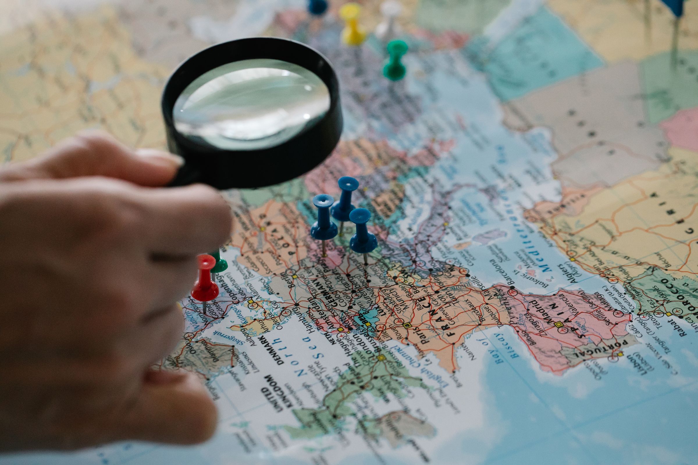 Loupe et épingles sur une carte du monde