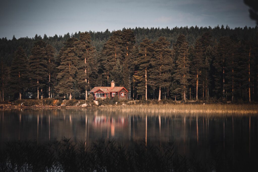 Maison de bois rouge au bord d’un lac