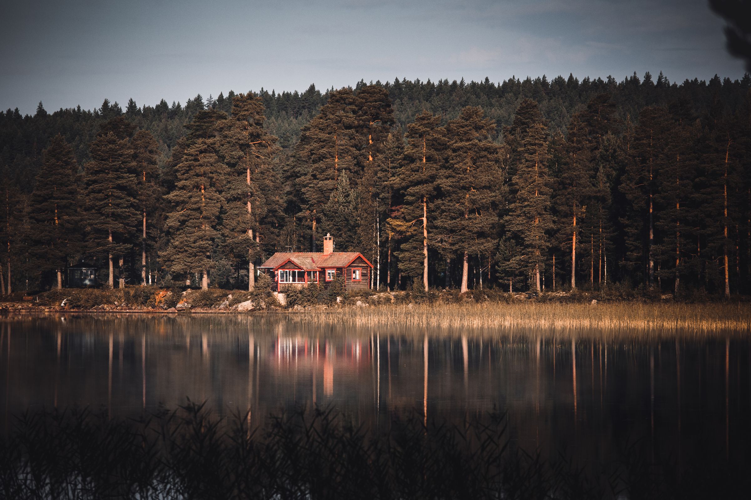 Maison de bois rouge au bord d’un lac